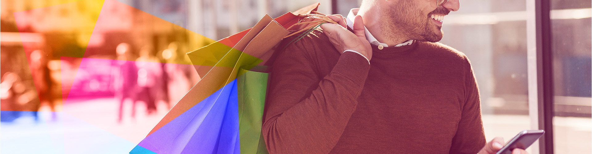 Blog banner featuring smiling man holding shopping bags over his shoulder and looking at his phone