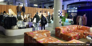 Photo of inside of UGG Feel House with clothing displays, shoppers browsing, and wrapping couch