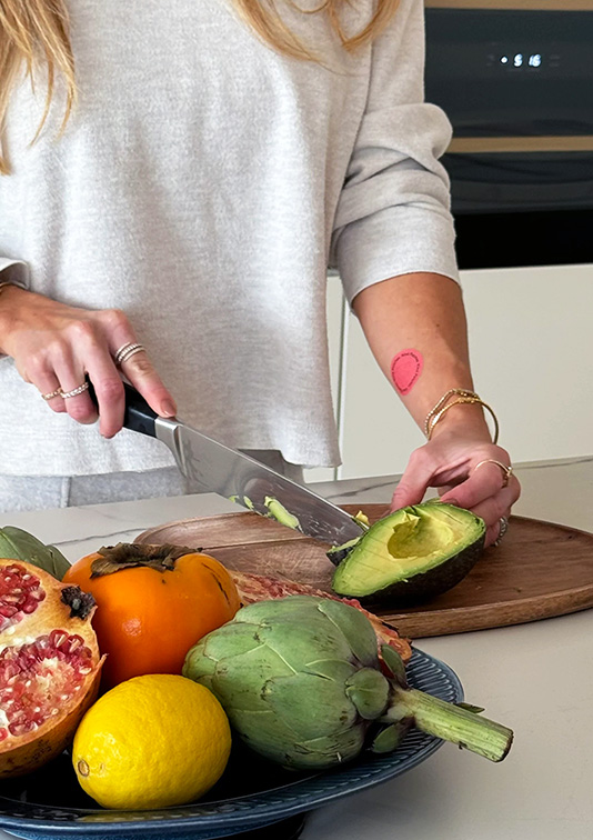 WSL Top Innovator featuring Kind Patches on a woman's arm as she cuts an avocado