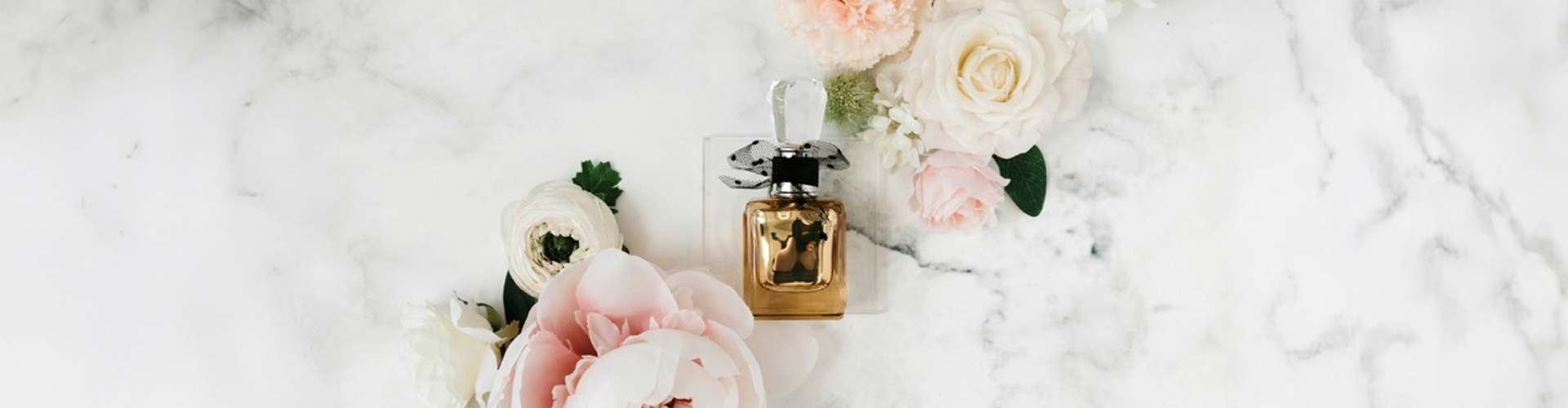 Case study banner featuring a gold bottle of perfume with pink and white flowers surrounding it